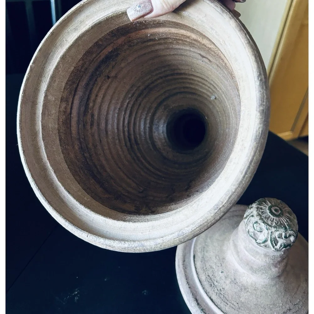 decorative terracotta urn with a distressed, rustic finish and a matching lid